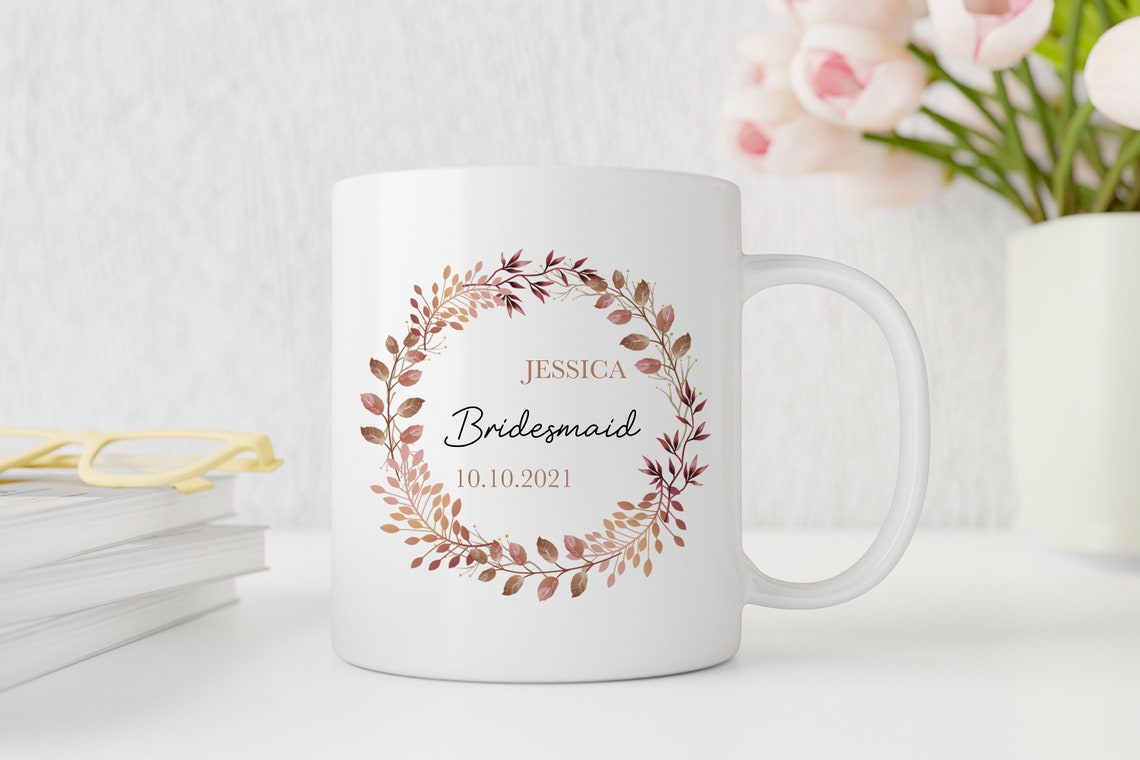 White personalised mug with floral design and text on a white surface with flowers in the background