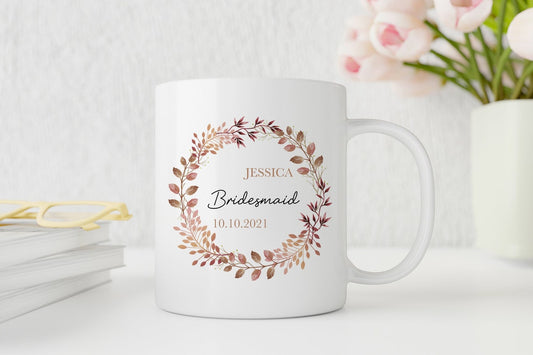 White personalised mug with floral design and text on a white surface with flowers in the background
