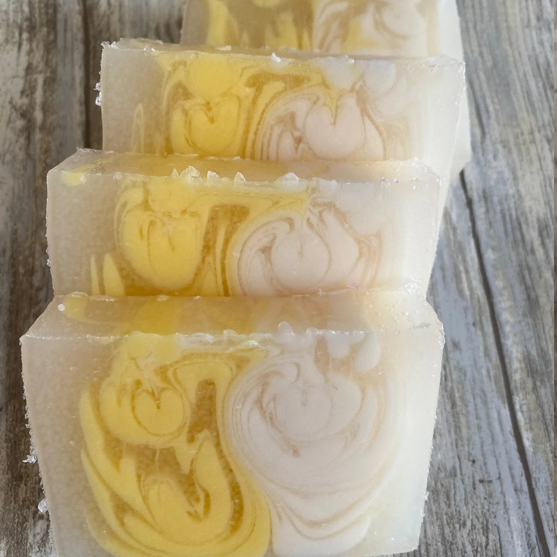 Vanilla soap with yellow and white swirls on a wooden surface