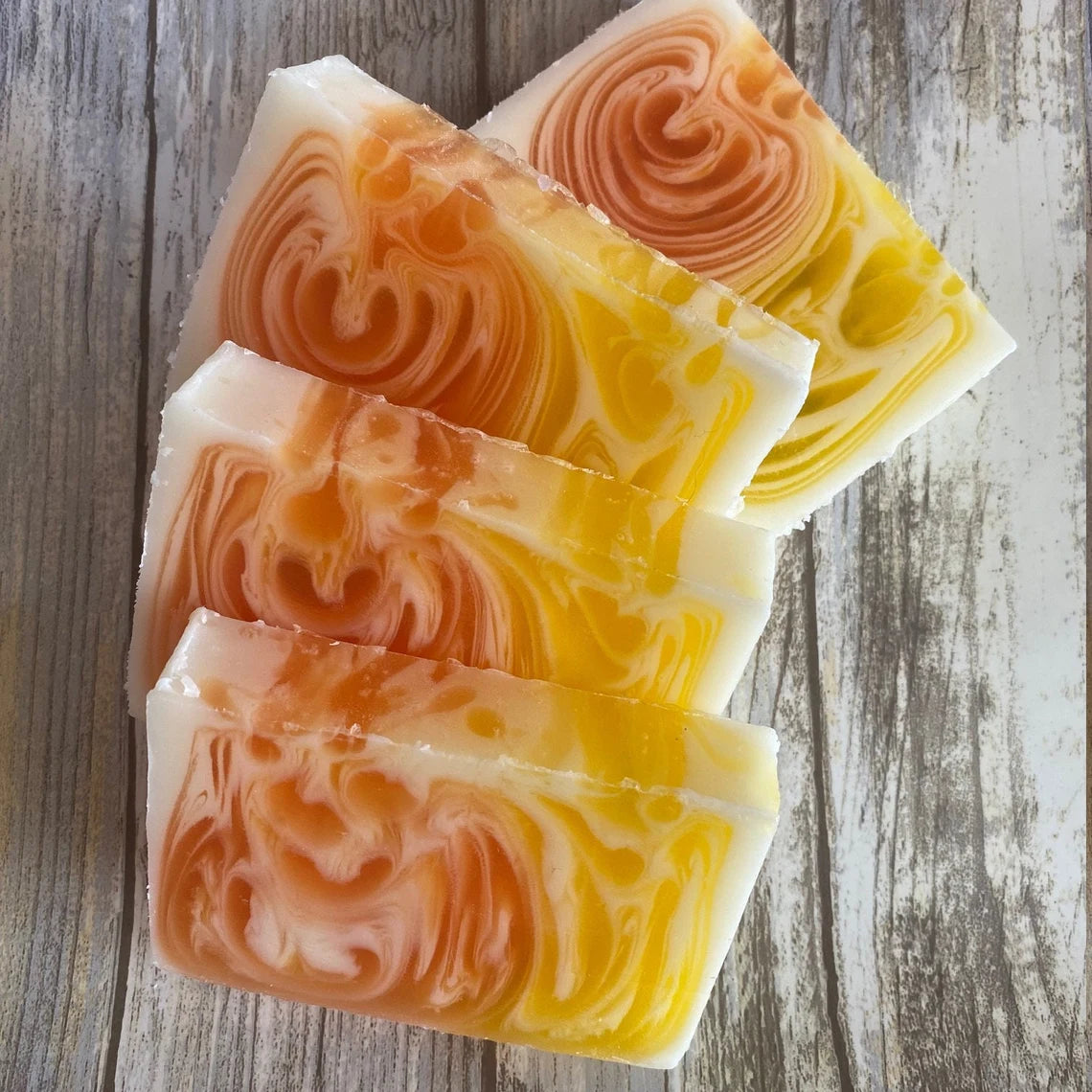 Orange and Ginger soap bars on a wooden surface