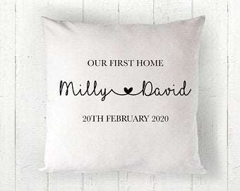 Personalised pillow with 'Our First Home' text and names on a wooden background