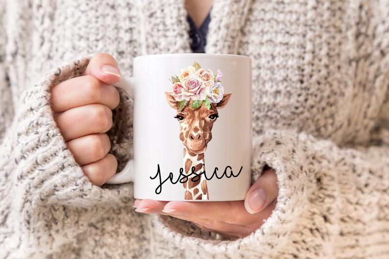 Person holding a personalised mug with a giraffe design and the name 'Jessica' on it.