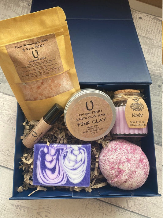Bath and body products including a bath bomb, soap, and salts in a blue box.