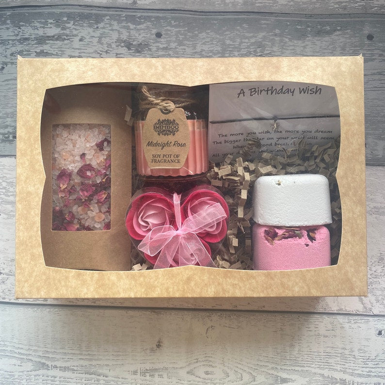 Gift set with shower steamers and soap flowers in a cardboard box on a wooden surface