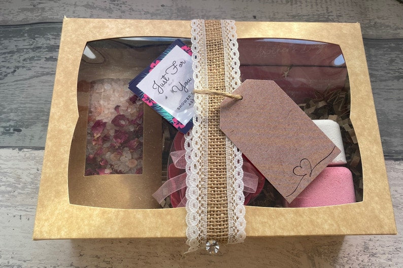 Gift set in a box with a decorative tag on a wooden surface