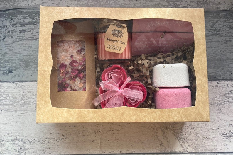 Bath product set with various items in a cardboard box on a wooden surface