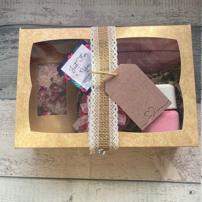 Gift set in a box with a decorative tag on a wooden surface