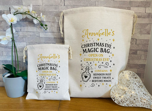 Two Christmas-themed bags with decorative text on a wooden surface.