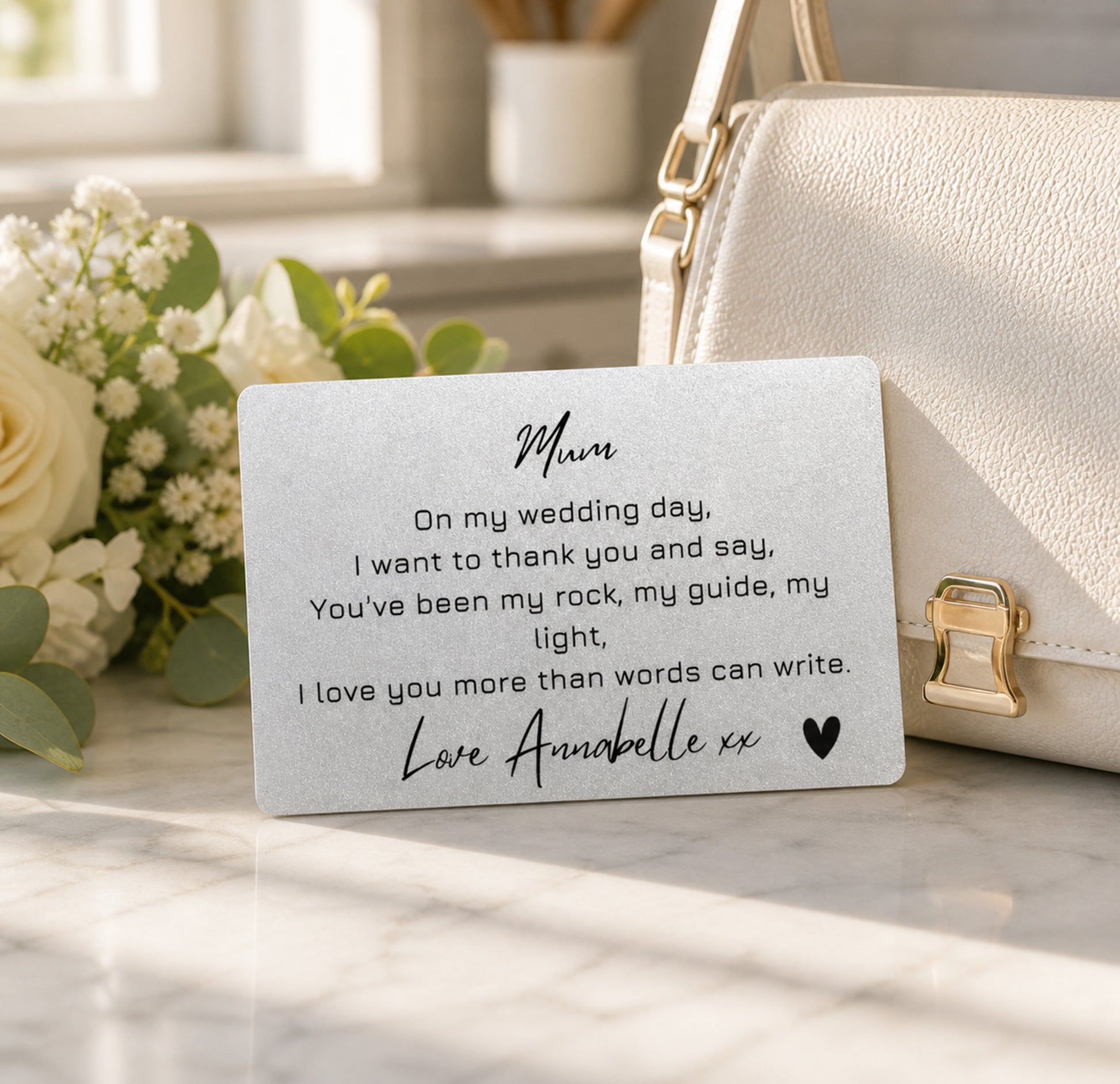 Card for 'Mum' on a marble surface with flowers and a handbag in the background