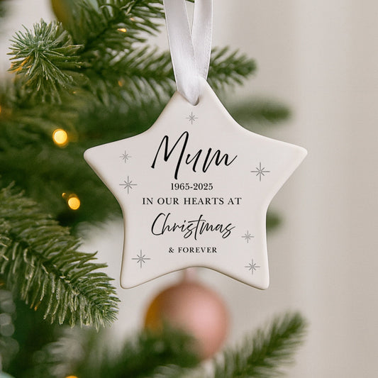 Star-shaped ornament with 'Mum 1965-2023 In Our Hearts at Christmas & Forever' text on a Christmas tree.