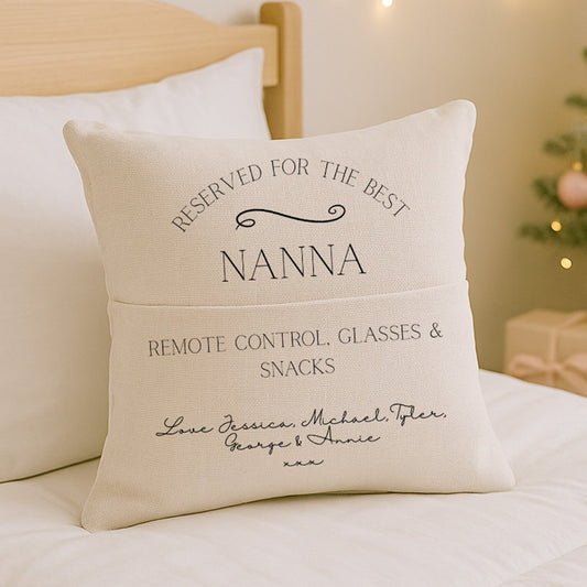 Decorative Nanny pillow with personalised text on a bed with a Christmas tree in the background