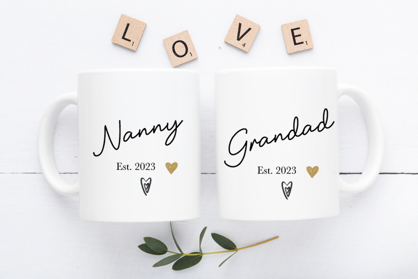 Two white mugs with 'Nanny' and 'Grandad' text on a light background