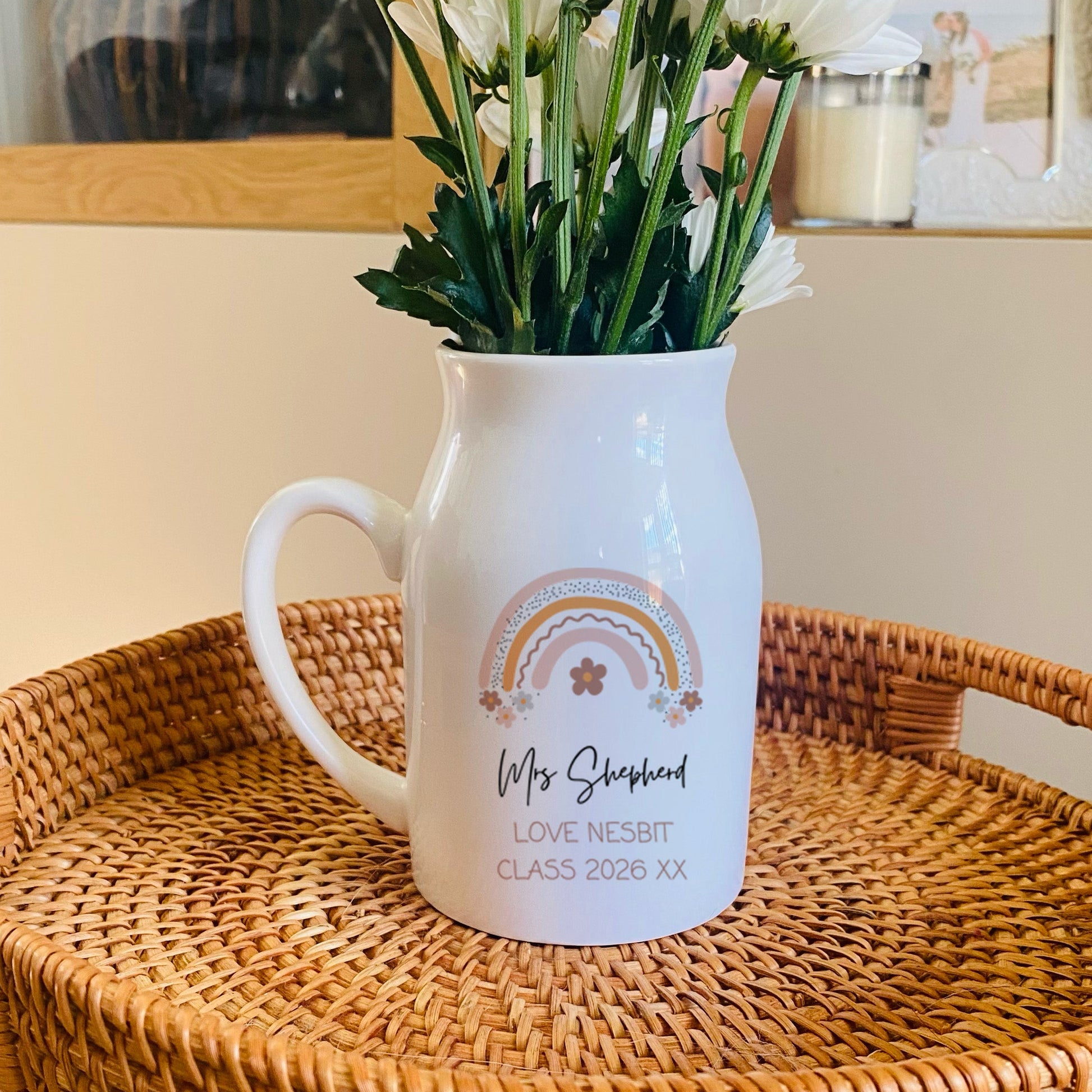 White Teacher pitcher with flowers on a woven tray in a home setting