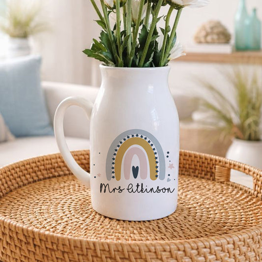 White pitcher with rainbow design on a woven tray in a living room setting