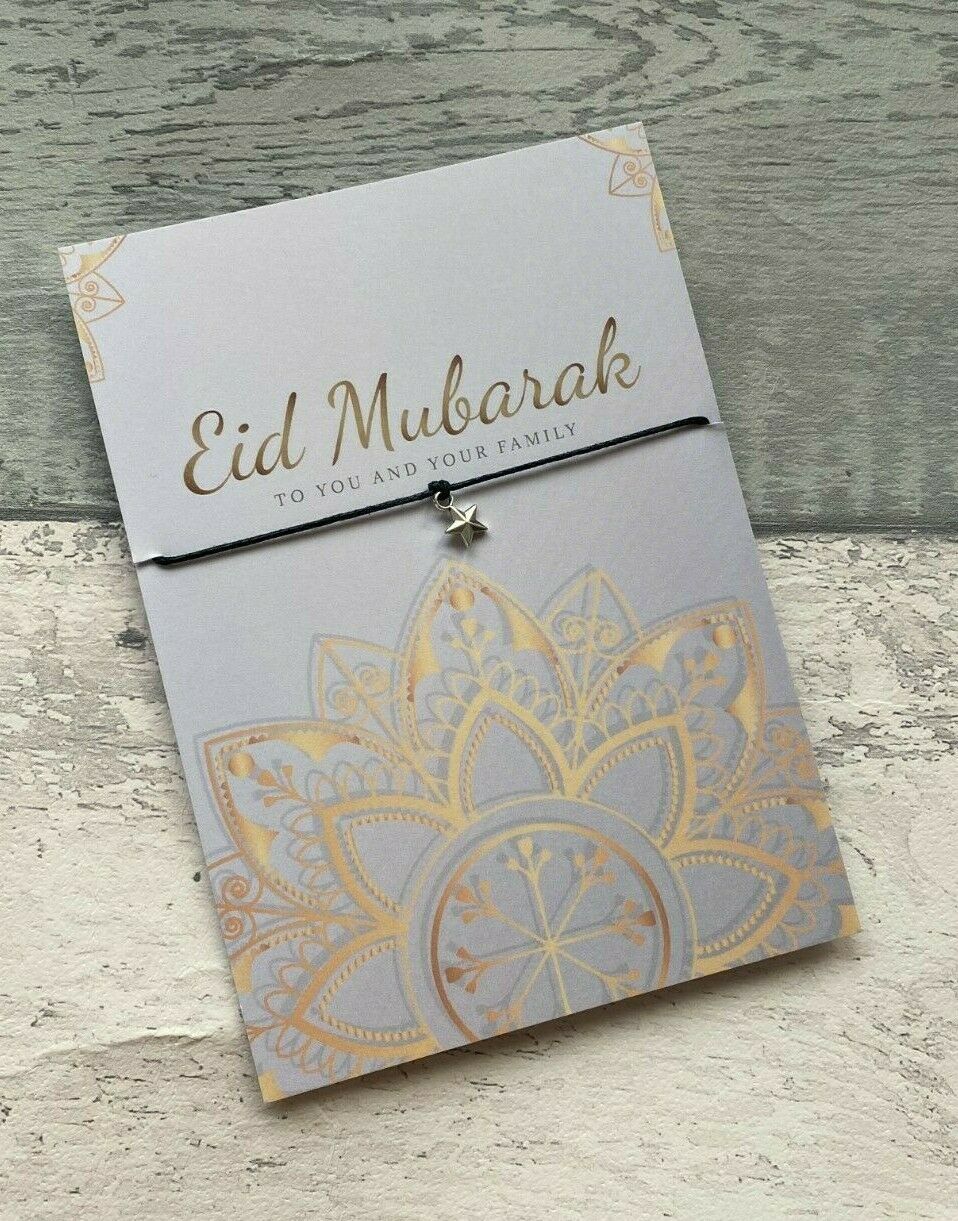 Eid Mubarak card with gold mandala design and necklace on a wooden surface