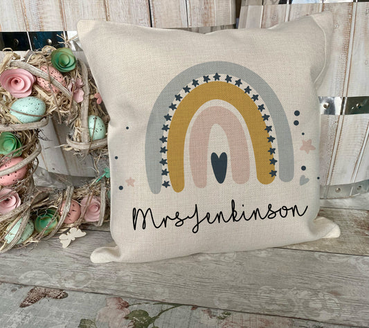 Decorative pillow with rainbow design and 'Mrs. Jenkins' text on a wooden surface. A perfect Teacher Gift

