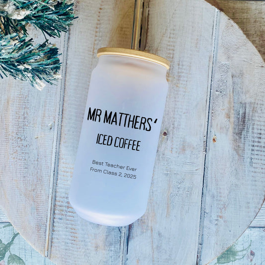 Jar labeled 'Mr. Matthers' Iced Coffee' on a rustic wooden surface with decorative elements.