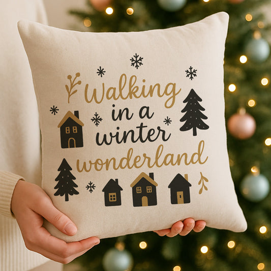 Decorative pillow with 'Walking in a winter wonderland' text held in front of a Christmas tree.